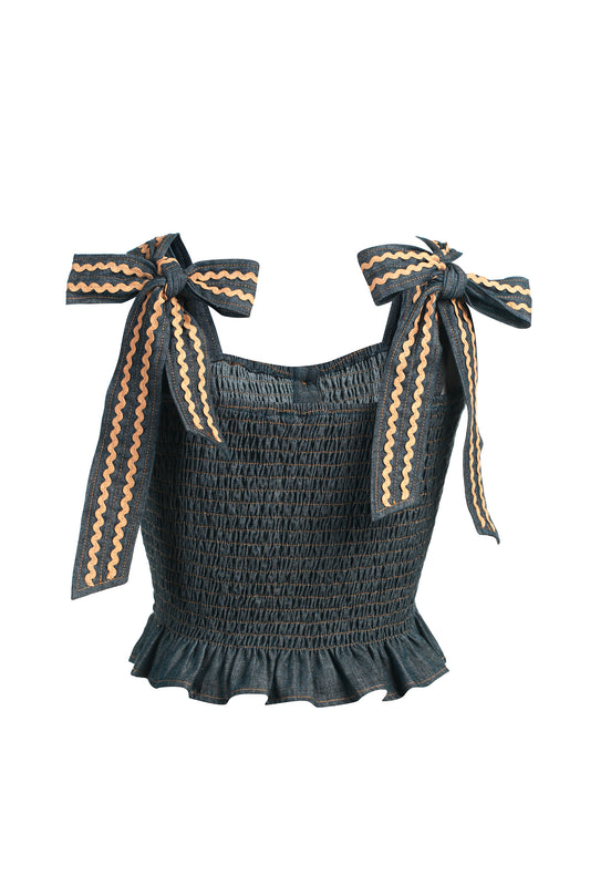 Denim smocked top with bow straps on a white background