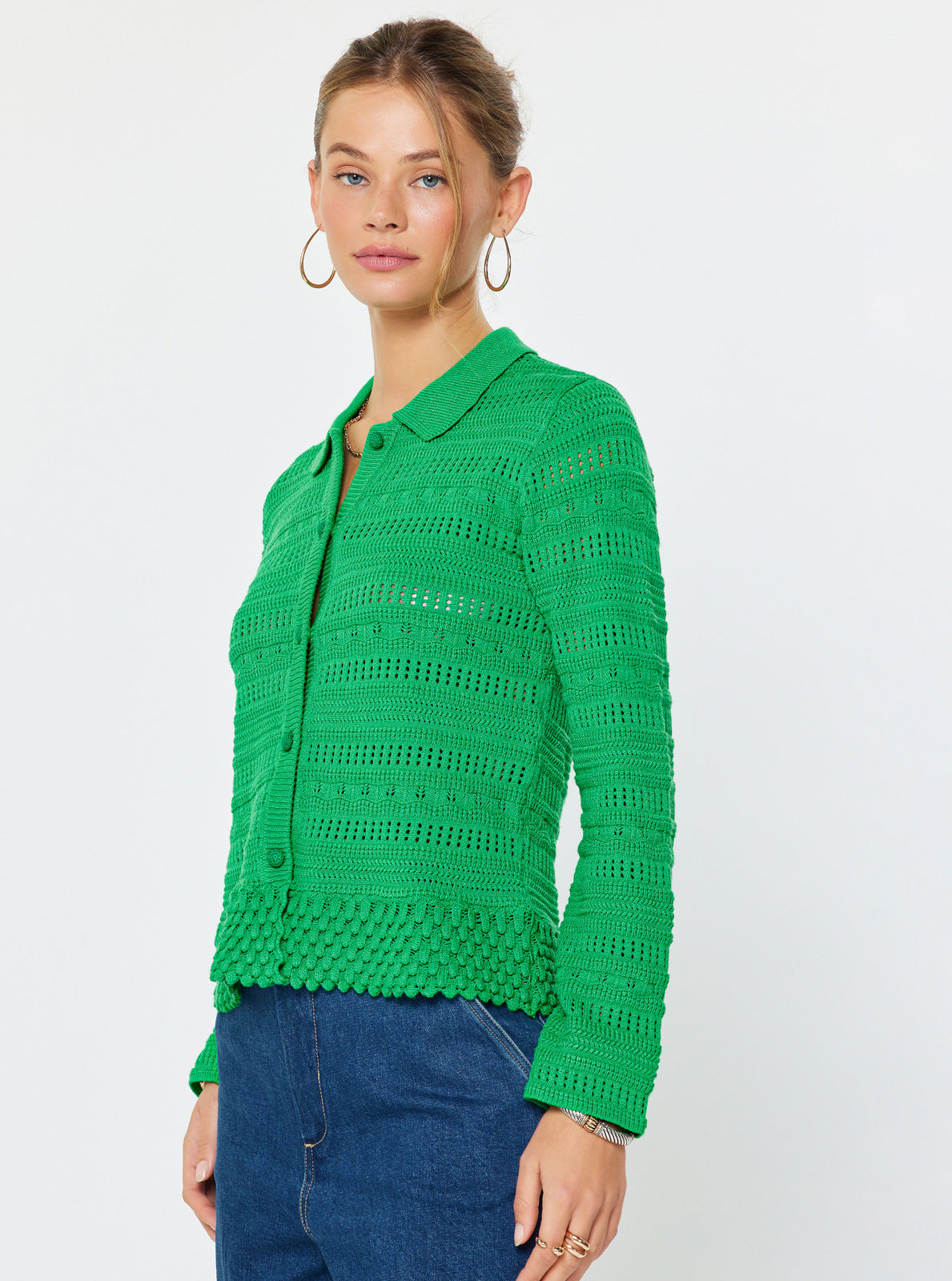 Woman wearing a green knitted cardigan on a white background